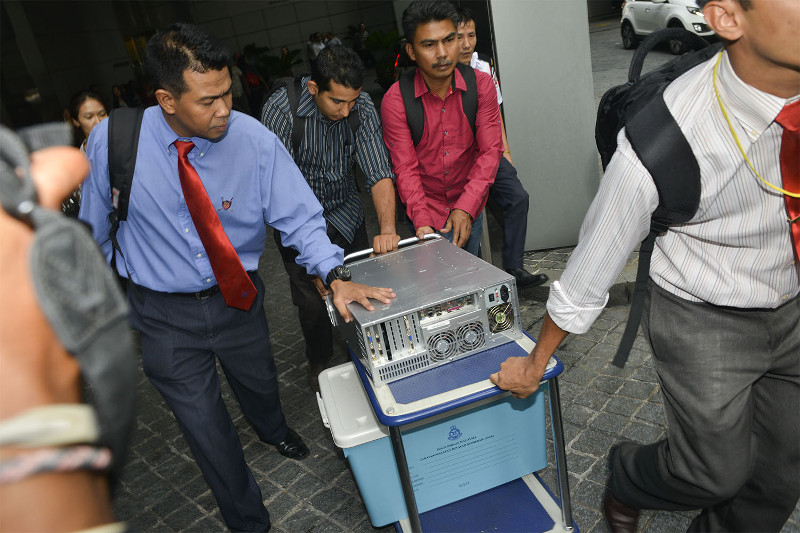 Officers from the special task force remove a CPU and a box from the 1Malaysia Development Berhad's office at Menara IMC in Kuala Lumpur, July 8, 2015. u00e2u20acu201d Picture by Yusof Mat Isa