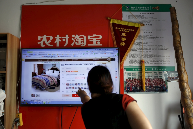 A customer points at a screen displaying a website of Alibaba's Taobao at a rural service centre in Yuzhao Village, Tonglu, Zhejiang province, China. u00e2u20acu201d Reuters pic