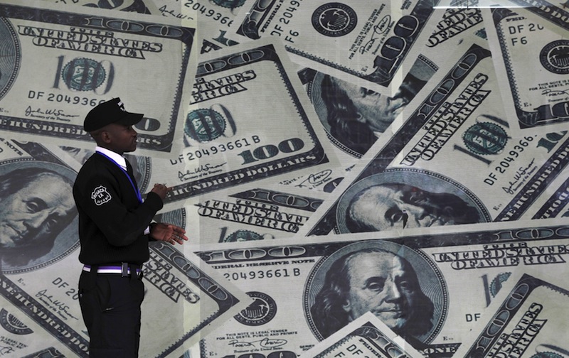 A security guard walks past a montage of US dollar bills outside a currency exchange bureau, ahead of a scheduled state visit by US President Barack Obama, in Kenya's capital Nairobi July 23, 2015.u00c2u00a0u00e2u20acu201d Reuters pic