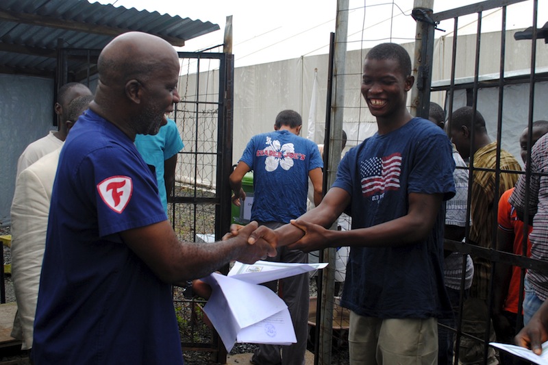 Cassius Kollie (right), 24, one of four people discharged on Monday from an Ebola treatment unit, receives a certificate for being cured of the disease in Paynesville, Liberia, July 20, 2015.u00c2u00a0u00e2u20acu201du00c2u00a0Reuters pic