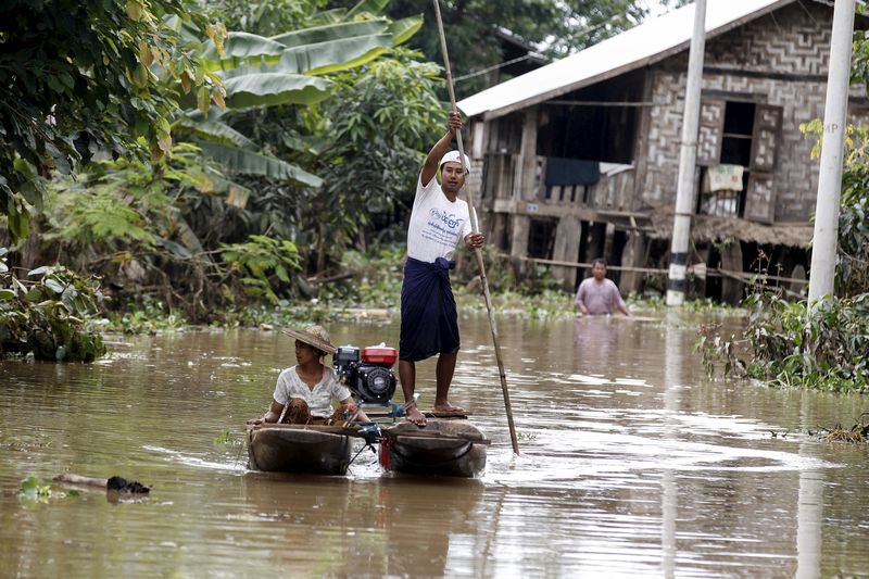 Residents ride a boat on a flooded area as they transport aid for their village at Kawlin township, Sagaing division, Myanmar July 23, 2015. u00e2u20acu201d Reuters pic  