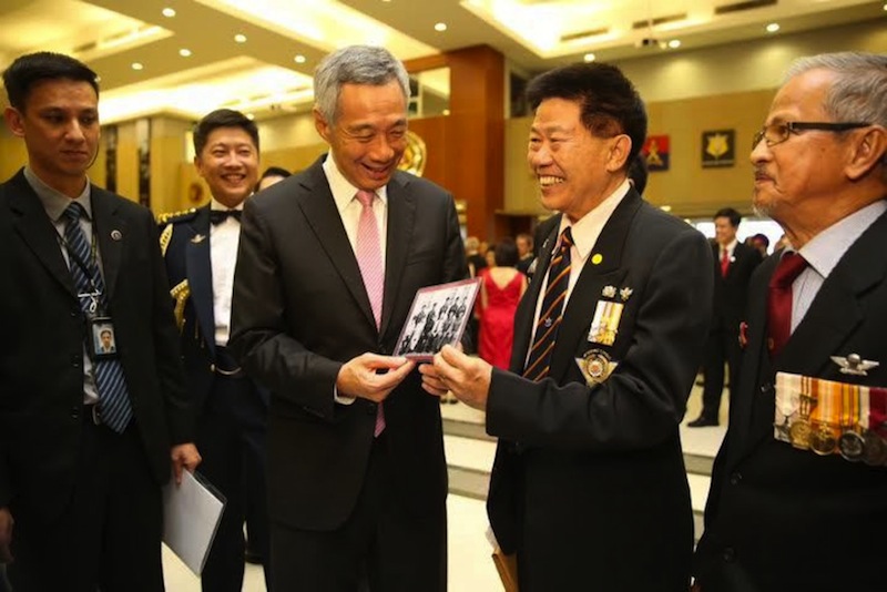 PM Lee Hsien Loong looking at an old group photo featuring himself and LTC (Ret) Chan Seck Sung (right) at Pasir Laba Camp to launch the SAF50 Commemorative Book. u00e2u20acu201du00c2u00a0TODAY pic