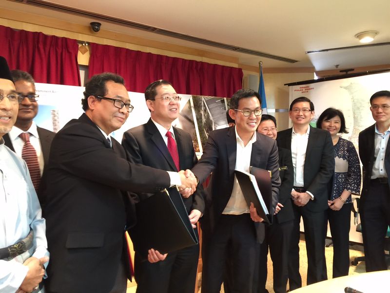 Lim Guan Eng witnesses the exchange of the signed JV between PDC's general manager Datuk Rosli Jaafar and EDIS chief executive officer Abel Ang (right). u00e2u20acu201d Picture by Opalyn Mok