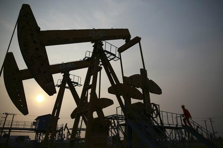 File picture shows a worker examining a pumpjack at a PetroChina oil field in Panjin, Liaoning province June 30, 2014. u00e2u20acu201d Reuters pic
