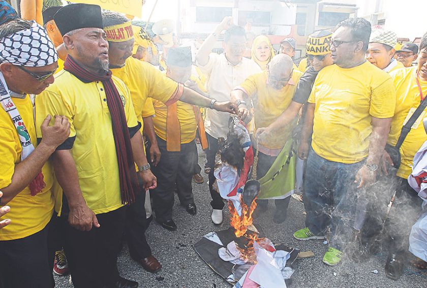 Protesters burn a political party’s flag during a protest in April. The writer says there is greater political discourse among a greater number of citizens now. — File picture