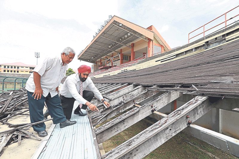 Amarjit and PCA secretary Megat Mohd Yasin inspect the deteriorating track yesterday. u00e2u20acu201d Picture by Marcus Pheong