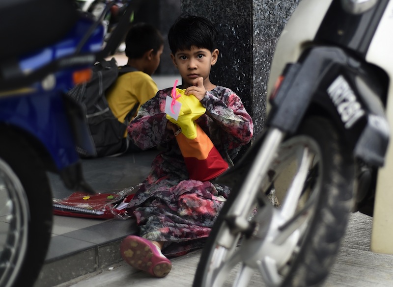A Malaysian homeless girl opens her gifts received during a government Ramadan event ahead of the Eid-al-Fitr festival in Kuala Lumpur on July 13, 2015. u00e2u20acu201du00c2u00a0AFP pic