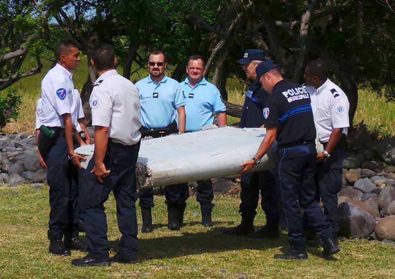 French gendarmes and police carry a large piece of plane debris which was found on the beach in Saint-Andre, on the French Indian Ocean island of La Reunion, July 29, 2015. u00e2u20acu2022 Reuters pic