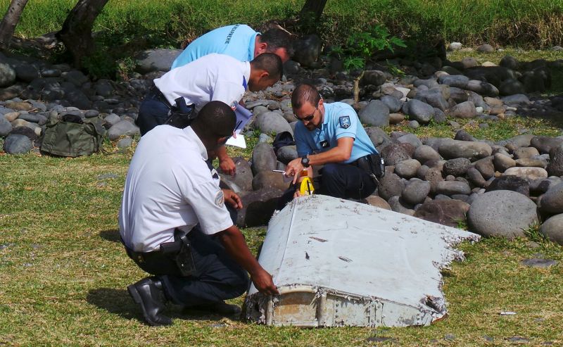 French gendarmes and police inspect a large piece of plane debris which was found on the beach in Saint-Andre, on the French Indian Ocean island of La Reunion, July 29, 2015. u00e2u20acu2022 Reuters pic