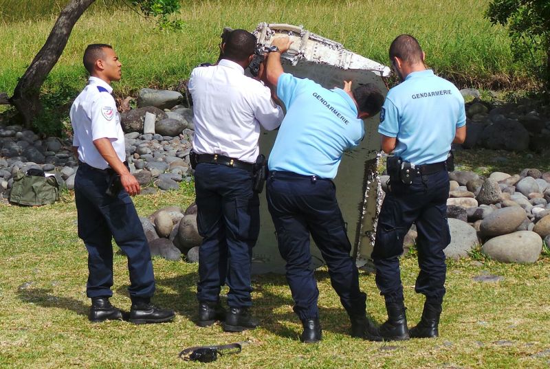 French gendarmes and police inspect a large piece of plane debris which was found on the beach in Saint-Andre, on the French Indian Ocean island of La Reunion, July 29, 2015. u00e2u20acu2022 Reuters pic