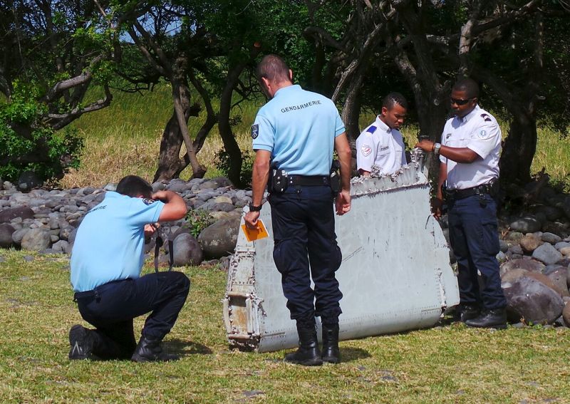 French gendarmes and police inspect a large piece of plane debris which was found on the beach in Saint-Andre, on the French Indian Ocean island of La Reunion, July 29, 2015. u00e2u20acu2022 Reuters pic