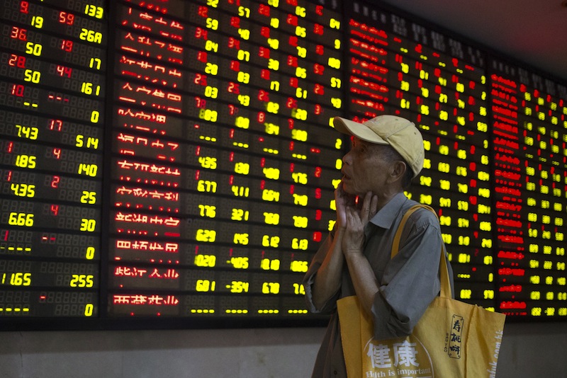 An investor looks at an electronic board showing stock information at a brokerage house in Nanjing, Jiangsu province, China, July 24, 2015. u00e2u20acu201d Reuters pic