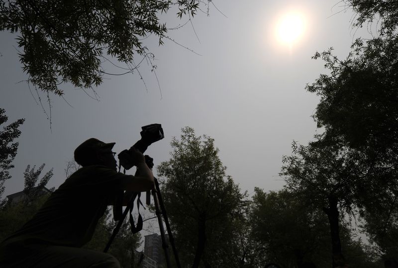 A man takes pictures of the Venus crossing in front of the Sun in Beijing on June 6, 2012. China is assembling the world's largest radio telescope in Guizhou. u00e2u20acu201d AFP pic