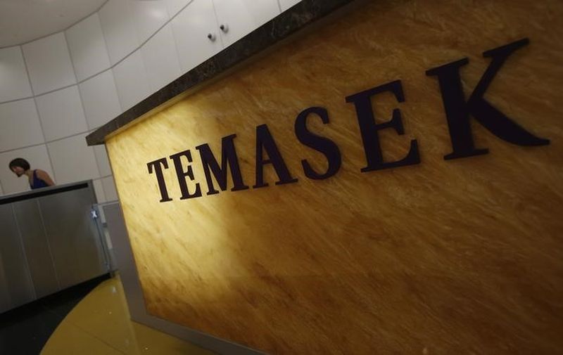 A woman passes a logo of state investor Temasek Holdings at its office in Singapore July 8, 2014.  u00e2u20acu201d Reuters pic