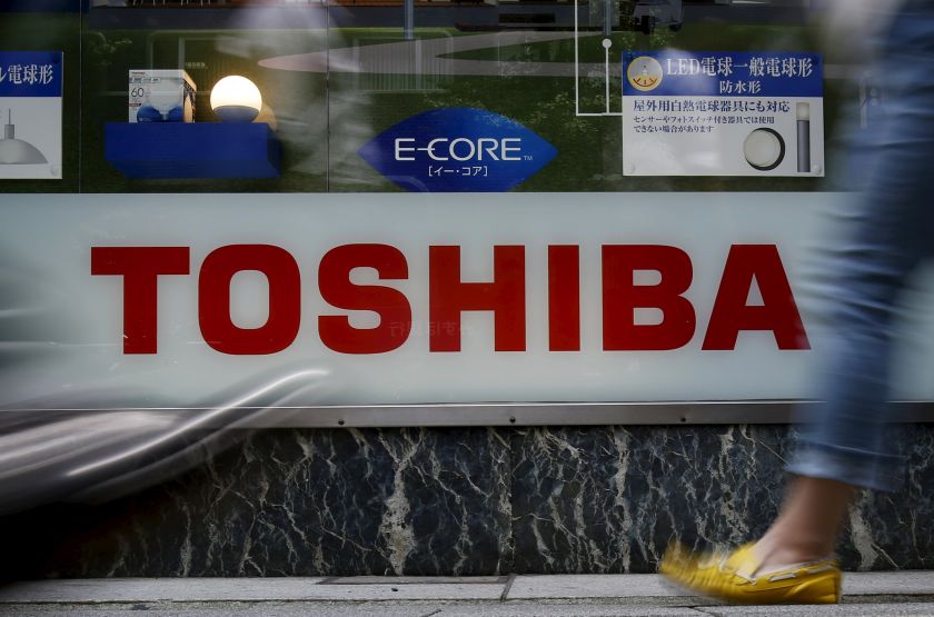 Pedestrians walk past a logo of Toshiba Corp outside an electronics retailer in Tokyo, Japan, June 25, 2015. u00e2u20acu201d Reuters pic