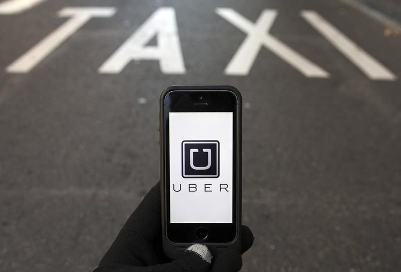 The logo of car-sharing service app Uber on a smartphone over a reserved lane for taxis in a street is seen in this photo illustration taken in Madrid on December 10, 2014. u00e2u20acu201d Reuters pic