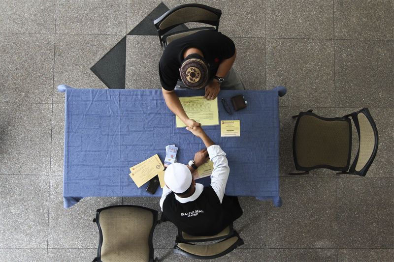A man is seen paying his u00e2u20acu02dczakatu00e2u20acu2122 at the Wilayah Persekutuan Mosque in Kuala Lumpur, July 1, 2015. u00e2u20acu2022 Picture by Yusof Mat Isa