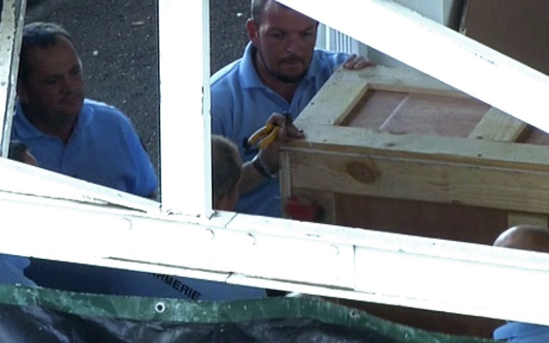 French gendarmes work on a oversized crate, believed to contain plane wreckage, in the cargo area of the airport in Saint-Denis on the French Indian Ocean island of La Reunion, in this still image taken from video shot on July 31, 2015.u00c2u00a0u00e2u20acu201d Reuters pic