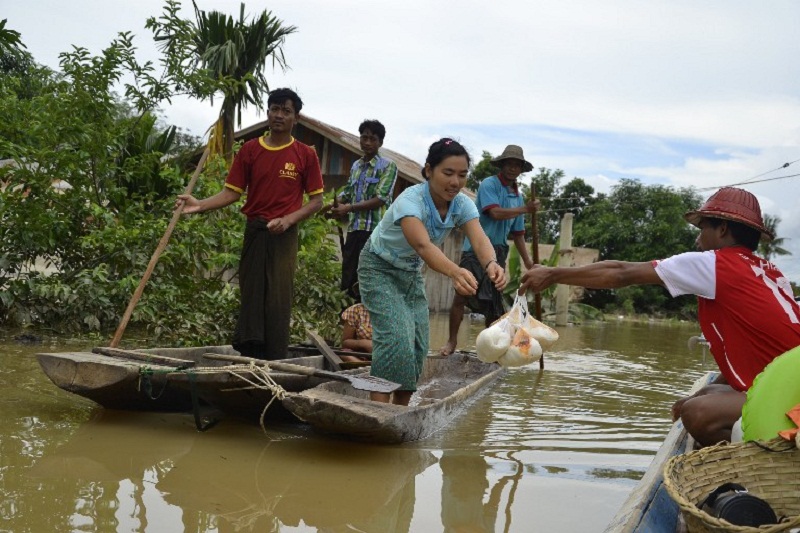 This photo taken on July 21, 2015 shows flood-affected residents receiving food from local donors at a village in Kawlin township, Sagaing division after torrential rains hit the area. u00e2u20acu201d AFP pic