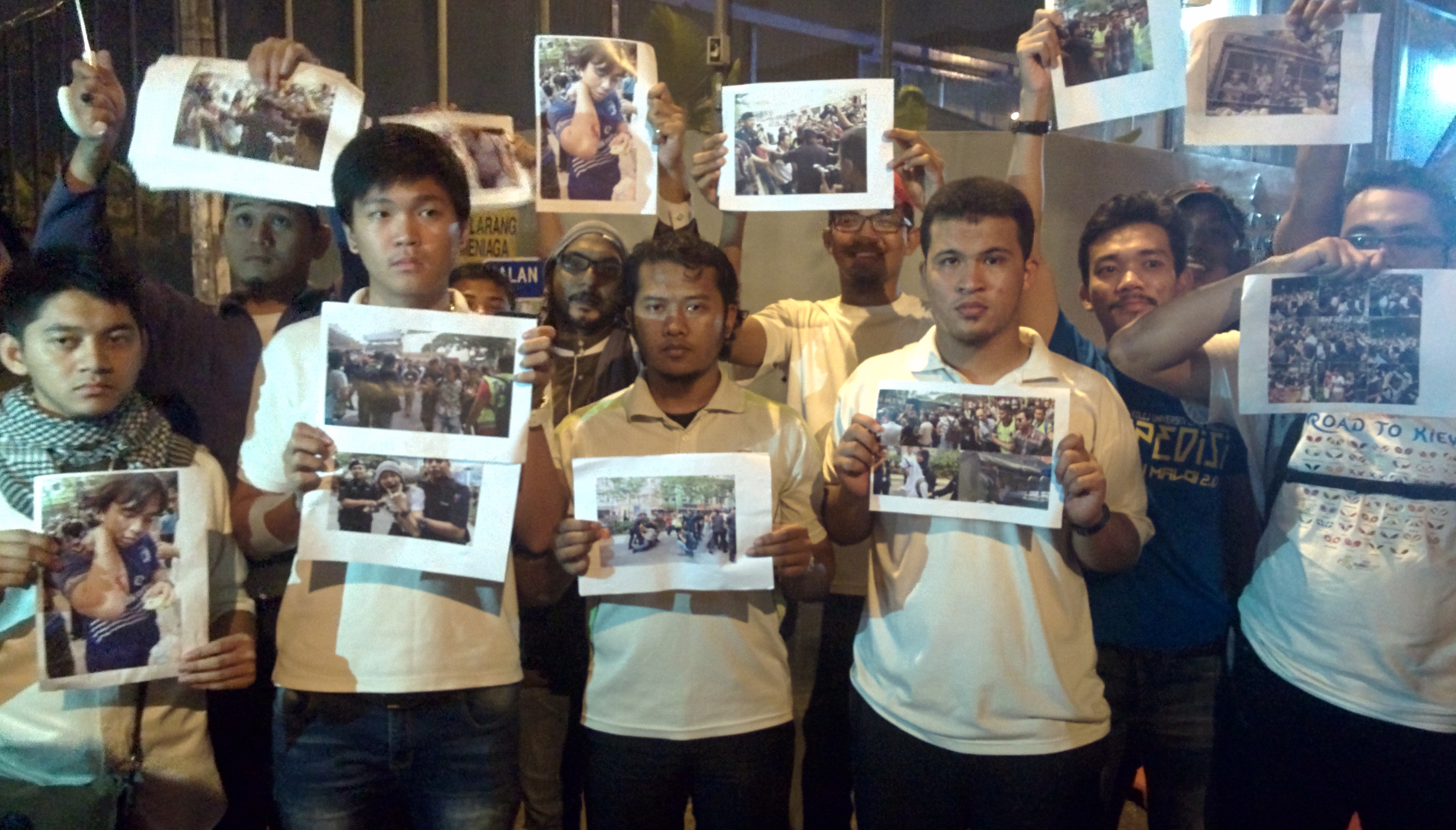 Demi Malaysia representatives holding up pictures of the police arresting protesters earlier today at #TangkapNajib rally, outside Jinjang Lockup in Kuala Lumpur, August 1, 2015. — Picture by Mayuri Mei Lin