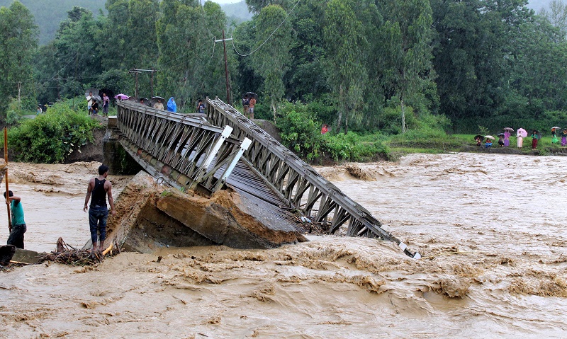 People look at the bridge which was washed away by the floodwaters in Thoubal District in Manipur state on August 1, 2015. u00e2u20acu201d AFP pic