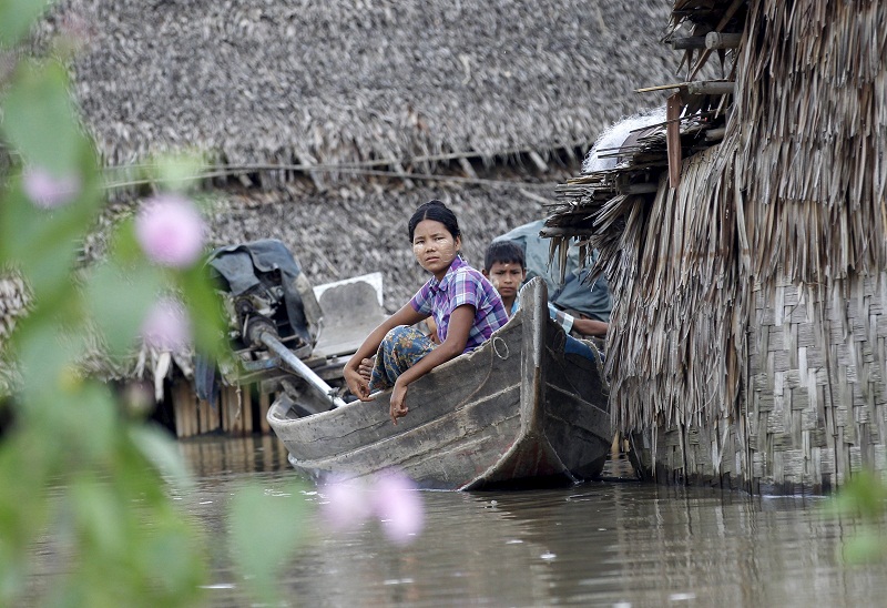 People sit on a boat near their home in a flooded village outside Zalun Township, Irrawaddy Delta, Myanmar, August 6, 2015. — Reuters pic