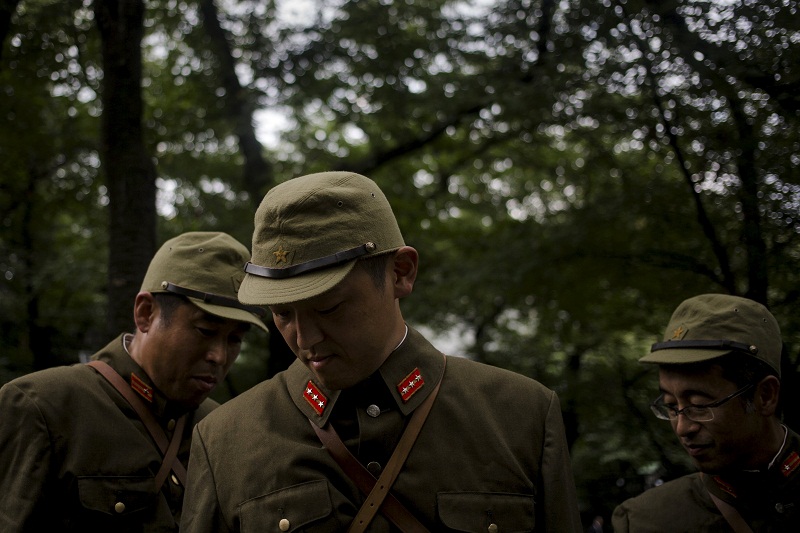 Men wear uniforms of Japanese imperial army soldiers at the precincts of the Yasukuni Shrine in Tokyo August 14, 2015, one day before Japan marks the 70th anniversary of its surrender in World War Two. — Reuters pic