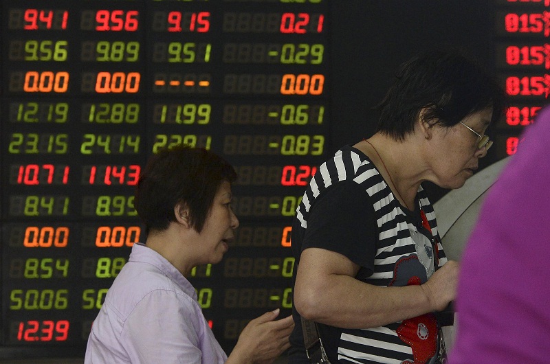 Investors look at computer screens in front of an electronic board showing stock information at a brokerage house in Shanghai, China, August 18, 2015. u00e2u20acu201d Reuters pic