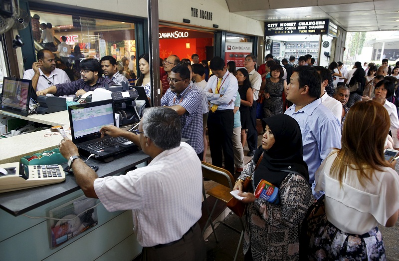 People, many looking to buy Malaysian ringgit, queue up outside moneychangers at the central business district in Singapore August 25, 2015. u00e2u20acu201d Reuters pic
