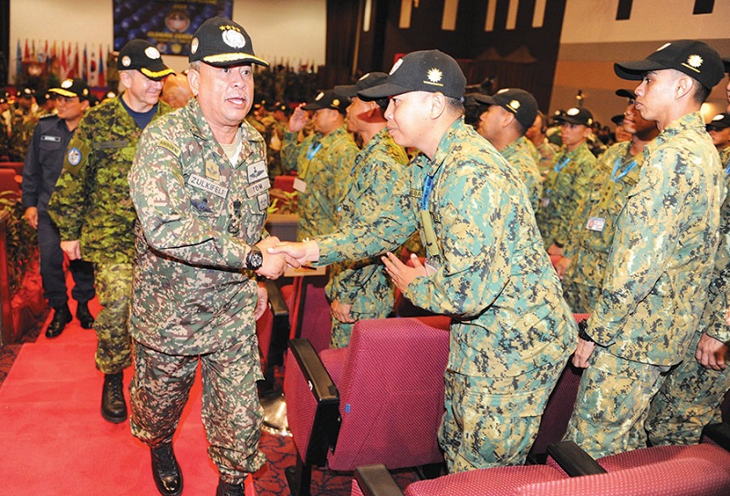 Zulkifeli greets army personnel from Brunei during the closing ceremony of a military exercise in Port Dickson yesterday. He said the army has no qualms about joining the Merdeka celebrations in Penang now that the state has adopted the national theme. u00e2u20ac