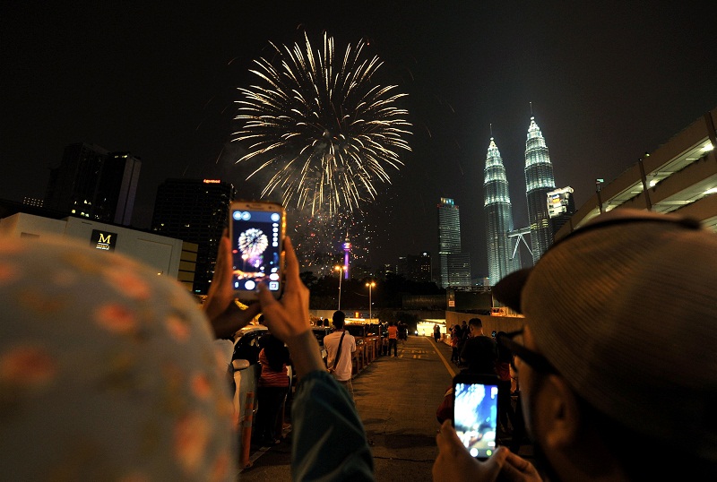 Spectators watch a fireworks display presented to celebrate the National Day at the Petronas Twin Towers in Kuala Lumpur, August 31, 2015. u00e2u20acu201d Bernama pic