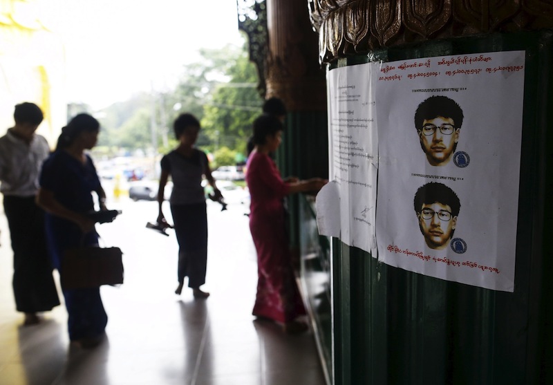 People line up as they leave their slippers near a wanted poster for the main suspect of a deadly bomb blast in Bangkok, Thailand,  put up by local authorities at Shwedagon pagoda in Yangon, Myanmar August 25, 2015. u00e2u20acu201du00c2u00a0Reuters pic