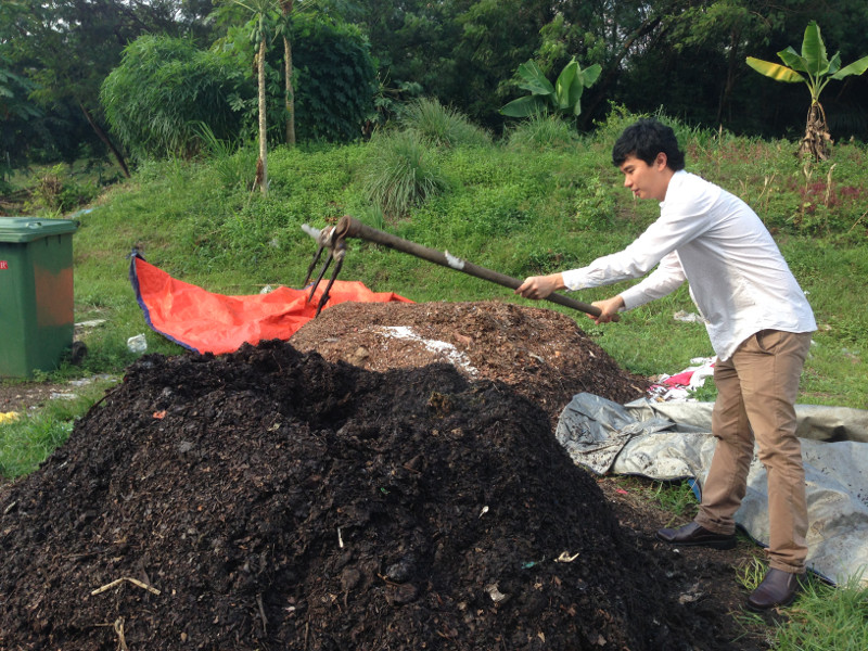Universiti Malaya’s Zero Waste Campaign Manager Jaron Kengat turns the compost at UM's composting facility. — Picture by Melissa Chi
