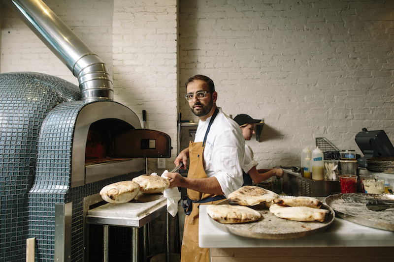 Chef Alon Shaya bakes pitas in a wood-fired oven at Shaya, which serves modern Israeli fare, in New Orleans, July 22, 2015. — Picture by William Widmer/The New York Times