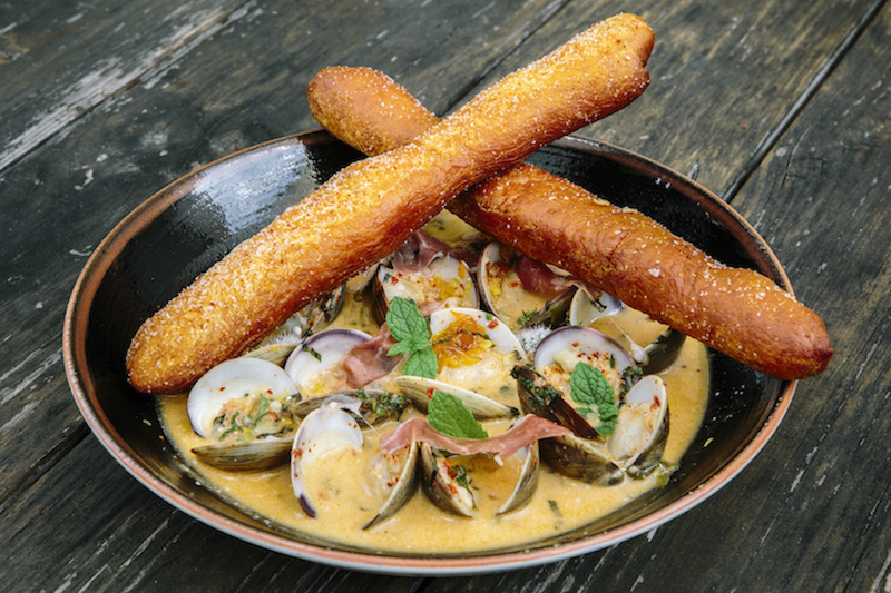 The pepper jelly braised Cedar Key clams with annatto beignets at MoPho, which opened in January of 2014, in New Orleans, July 23, 2015. — Picture by William Widmer/The New York Times