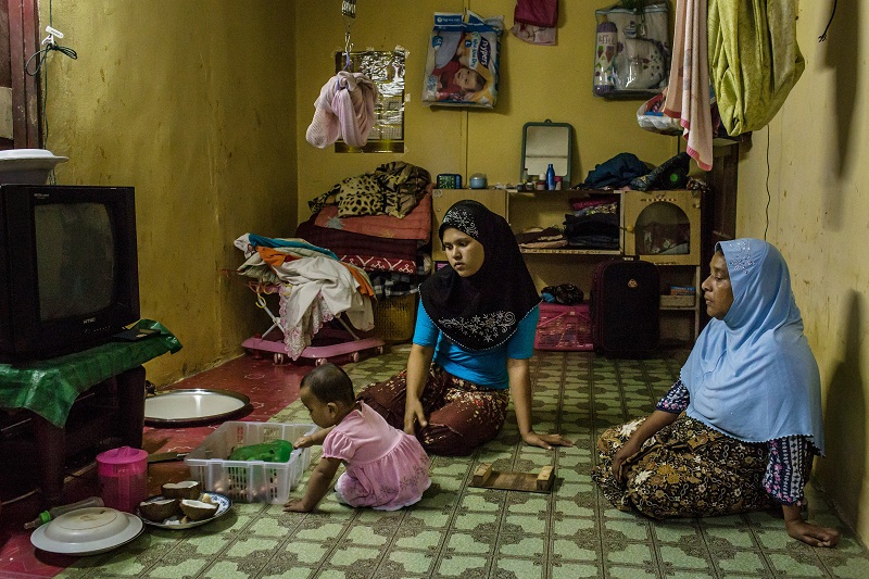 Ambiya Khatu, centre, who married a man who paid for her release from smugglers in Thailand, watches her niece with her mother, Mabiya Khatu, at home in Kuala Lumpur, Malaysia, June 1, 2015. u00e2u20acu201d Picture by Mauricio Lima for The New York Times