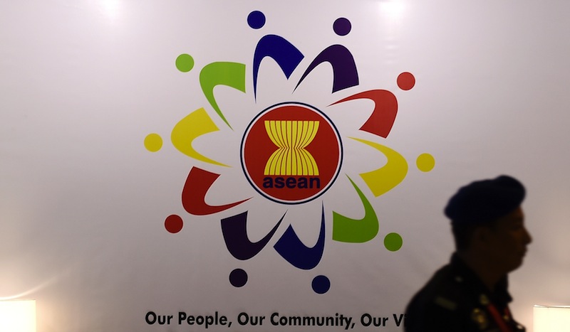 A Malaysian police official walks past the Association of Southeast Asian Nations logo at the Putra World Trade Centre in Kuala Lumpur on August 3, 2015. u00e2u20acu201d AFP pic
