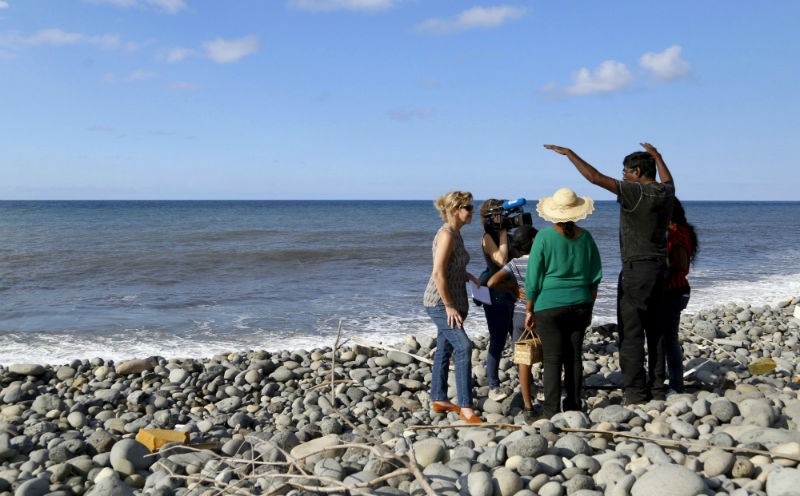 People talk to journalists on the beach where a large piece of plane debris was found, in Saint-Andre, on the French Indian Ocean island of La Reunion, August 1, 2015. u00e2u20acu201d Reuters pic