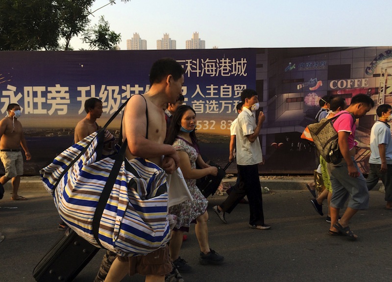 People leave their home for temporary shelters near the site of the explosions, at the Binhai new district, Tianjin, August 13, 2015. u00e2u20acu201d Reuters pic