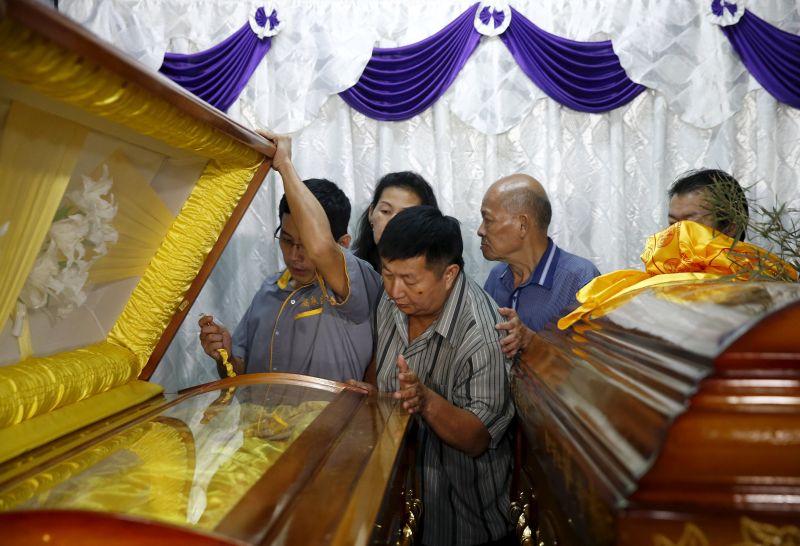 Neoh Hock Guan (centre), injured in Monday's blast in Bangkok, views the coffins of his wife and son who were killed in the attack, at his home in Butterworth, Malaysia, August 20, 2015. u00e2u20acu2022 Reuters pic