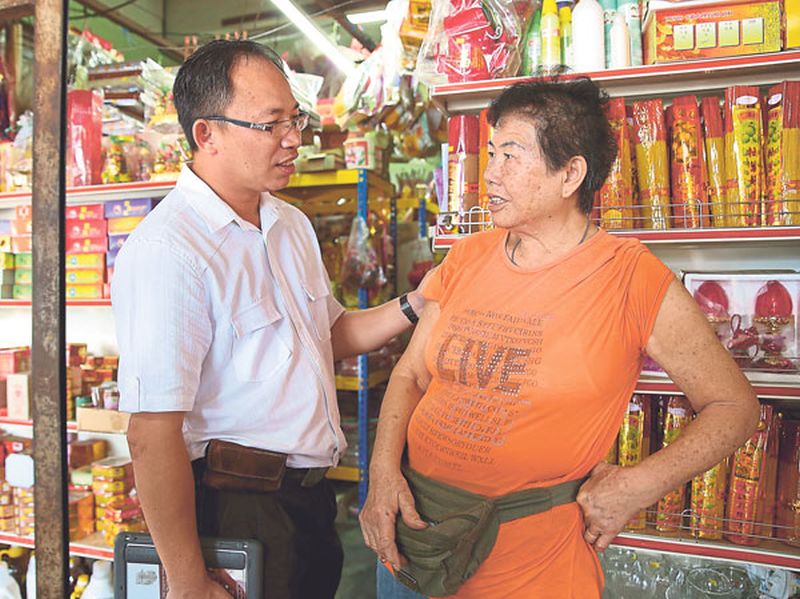 Bercham assemblyman Cheong Chee Khing comforts Phong Say Moi (right) at her shop in Kampung Tawas. u00e2u20acu201d Picture by Marcus Pheong