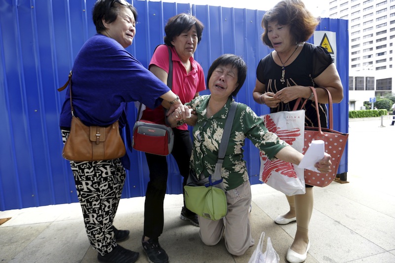 Bao Lanfang, whose son, daughter-in-law and 3-year-old granddaughter were aboard Malaysia Airlines flight MH370, kneels down in front of media before she and other family members express their demands in Beijing August 6, 2015. u00e2u20acu201d Reuters pic