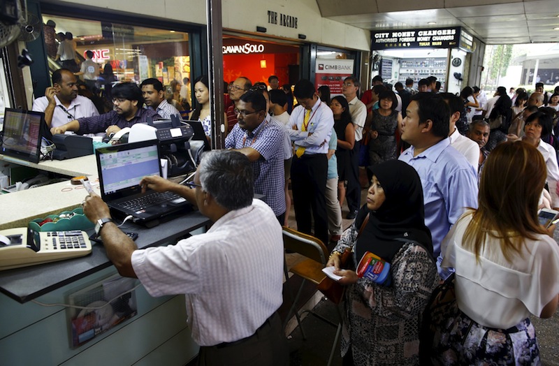 People, many looking to buy Malaysian ringgit, queue up outside moneychangers at the central business district in Singapore August 25, 2015. u00e2u20acu201d Reuters pic