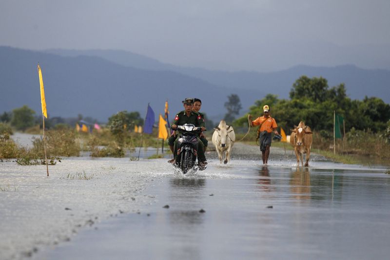 Soldiers ride a motorbike on a flooded road at Kawlin township, Sagaing division, Myanmar July 23, 2015. u00e2u20acu201d Reuters pic 