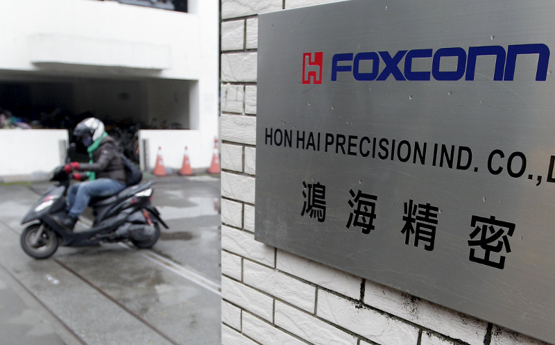 File picture shows a motorcyclist riding past the entrance of the headquarters of Hon Hai, which is also known by its trading name Foxconn, in Tucheng, New Taipei city, Taiwan. u00e2u20acu201d Reuters pic