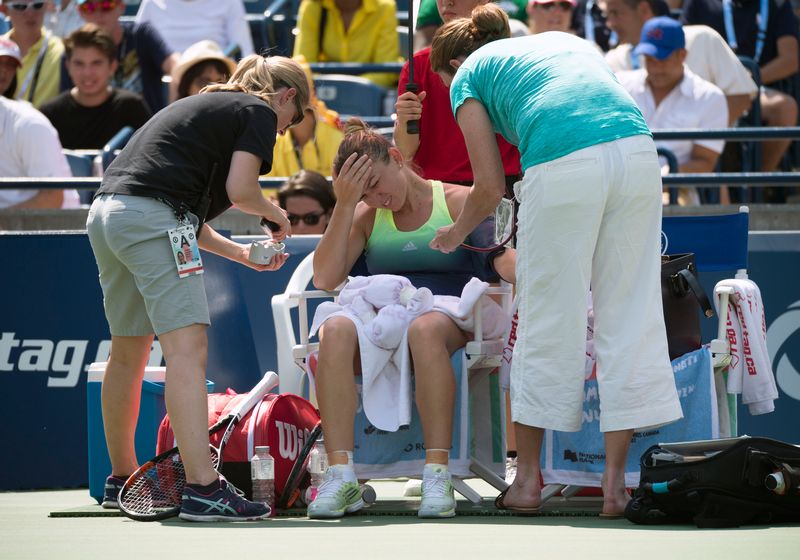 Simona Halep is looked after by the training and medical staff during a break in the Rogers Cup women's singles final at the Aviva Centre, Toronto, August 16, 2015. u00e2u20acu201d Reuters pic 