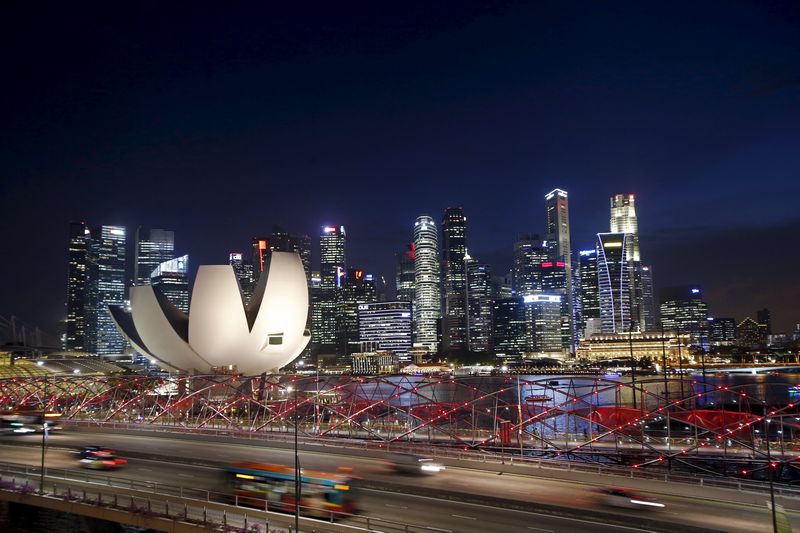 Vehicles travel on a bridge past the ArtScience Museum (left), Helix Bridge (lit in red) and the skyline of the central business district in Singapore July 29, 2015. u00e2u20acu201d Reuters pic