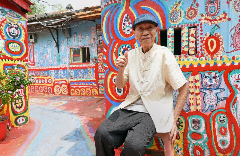 Artist Huang Yung-fu, 93, next to his artwork in the Rainbow Village in the Nantun district of Taiwan's central Taichung, August 19, 2015. — AFP pic