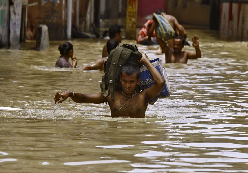 Flood-affected people carry their belongings as they move to safer grounds along a flooded street at West Midnapore district in West Bengal, India, August 4, 2015. u00e2u20acu201d Reuters pic 