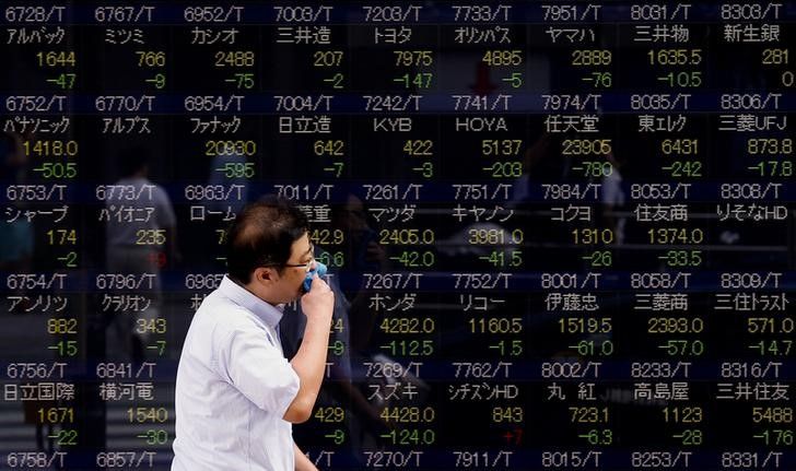 A man walks past a display showing stock prices in Tokyo August 12, 2015. Japanu00e2u20acu2122s Topix index slid 0.2 per cent in early trade, August 14, 2015. u00e2u20acu201d Reuters pic